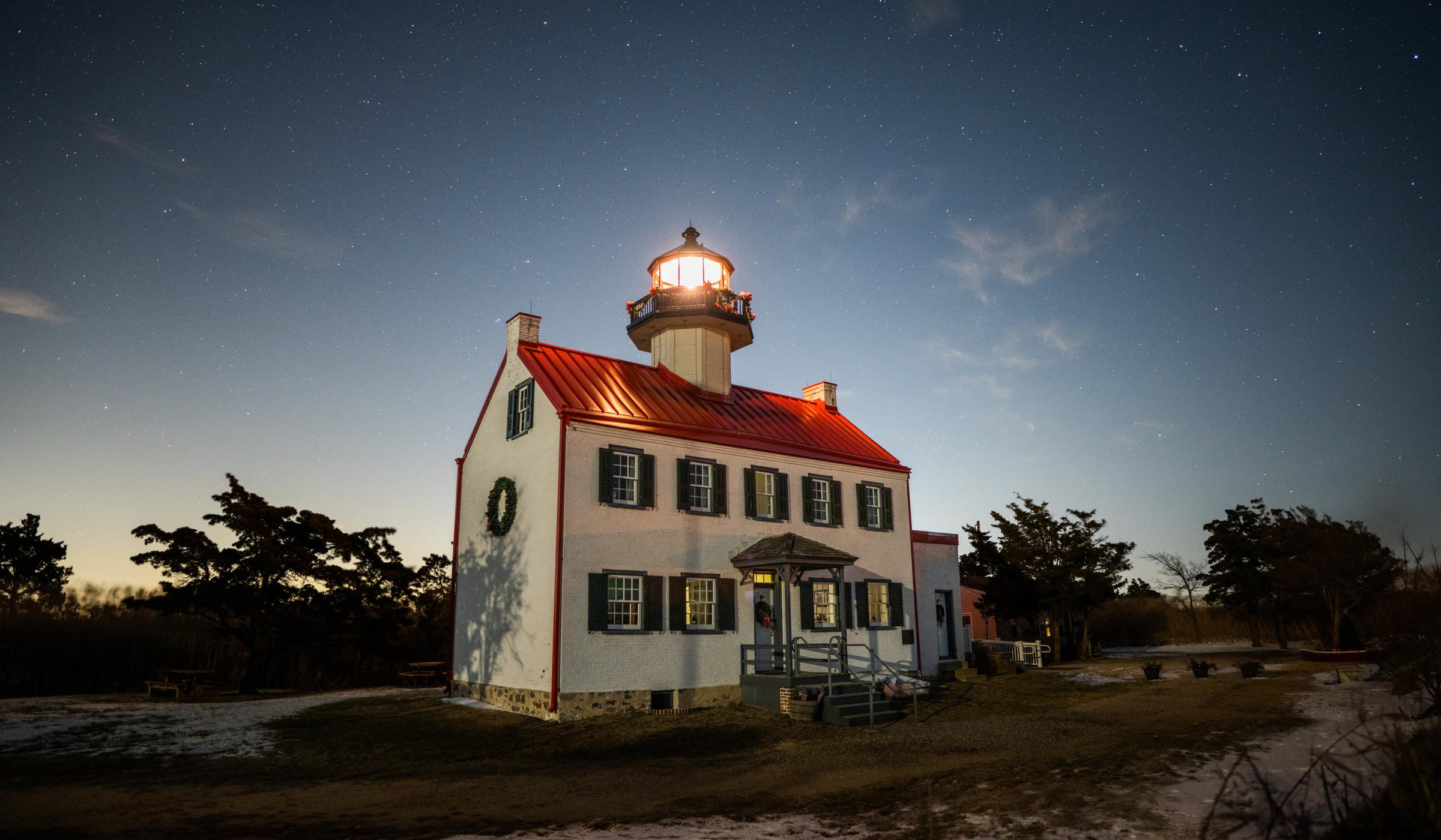 Old white house with lighthouse tower on the roof.
